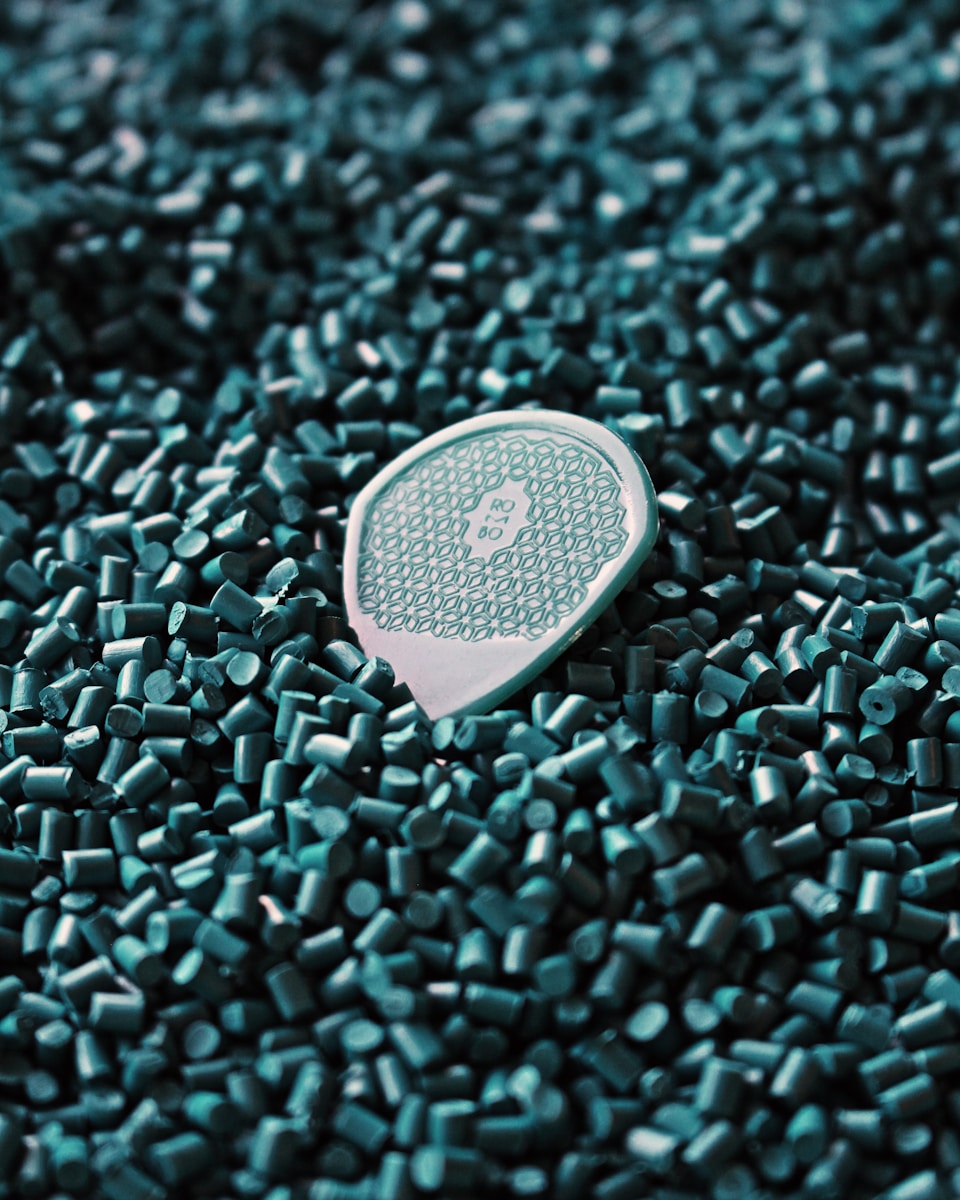 a close up of a tennis racket laying on a pile of green tiles