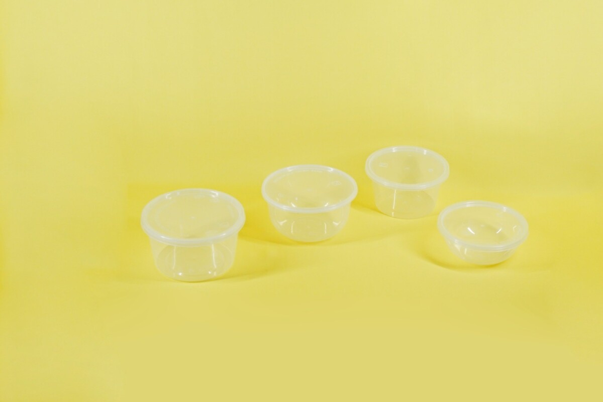 a group of three plastic containers sitting on top of a yellow surface