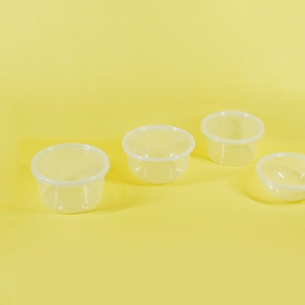 a group of three plastic containers sitting on top of a yellow surface