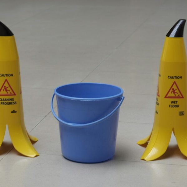 yellow and black plastic bottle beside blue plastic cup