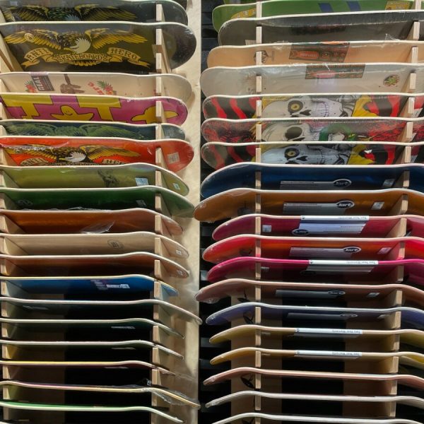 a rack filled with lots of different colored skateboards